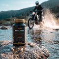 Evolytes en cápsulas sobre una roca junto a un río mientras un piloto de enduro cruza el agua